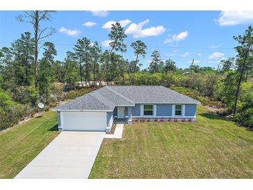 Inviting single-story home featuring a well-manicured lawn and attached two-car garage at 17787 Sw 22Nd Ave, Ocala, FL 34473