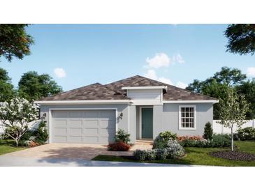 Charming single-story home with a gray exterior, two-car garage, and beautifully landscaped front yard at 1785 Columbus Path, St Cloud, FL 34771