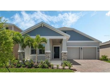 Charming single-Gathering home featuring a two-car garage, manicured lawn, and tasteful stone accents at 1908 Blissful Dr, Kissimmee, FL 34744