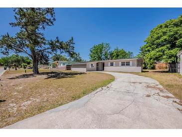 Charming single-story home featuring a spacious yard and a long, curved driveway at 3718 Mitchell Rd, Orlando, FL 32808