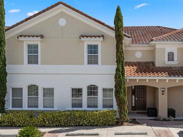 Inviting two-story townhome features a classic facade, a terracotta-tiled roof, and mature landscaping at 4722 Terrasonesta Dr, Davenport, FL 33837