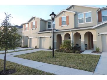 Townhome exterior with manicured lawn, neutral color scheme and decorative shutters at 5123 Crown Haven Dr, Kissimmee, FL 34746
