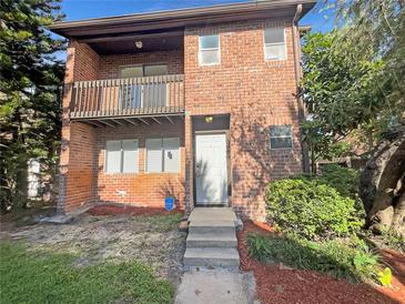 Charming two-story brick home featuring a balcony and well-maintained landscaping at 5126 Picadilly Circus Ct # 11, Orlando, FL 32839