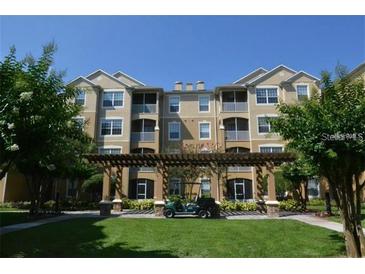 Beautiful condo with well-manicured lawn and a golf cart in the covered area in front of the building at 6434 Cava Alta Dr # 303, Orlando, FL 32835
