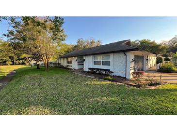 Charming single-story home featuring stucco exterior and a well-manicured lawn, and attached garage at 7730 Broken Arrow Trl, Winter Park, FL 32792