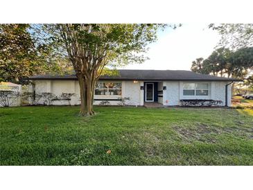 Charming single-story home featuring a well-maintained lawn and front landscaping at 7730 Broken Arrow Trl, Winter Park, FL 32792