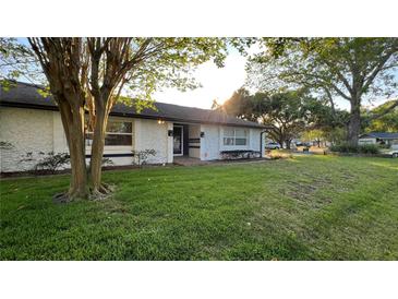Charming single-story home with lush front lawn and mature trees in a quiet neighborhood at 7730 Broken Arrow Trl, Winter Park, FL 32792