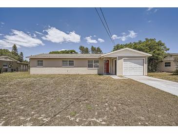 Charming single-story home with a red front door and attached one car garage at 1602 Sheffield Rd, Leesburg, FL 34748