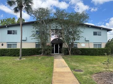 Charming two-story condo building with well-maintained landscaping, a walkway, and trees at 1695 Lee Rd # E214, Winter Park, FL 32789