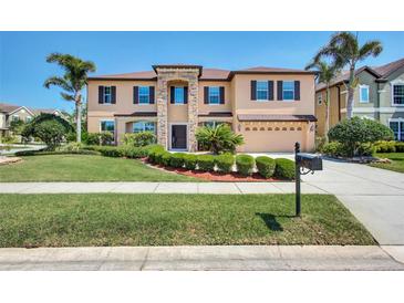 Stunning two-story home with a stone-accented facade, well-manicured lawn, and lush landscaping at 17117 Cypress Preserve Pkwy, Orlando, FL 32820