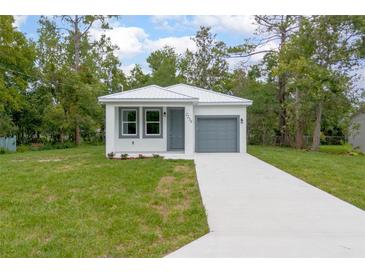 Charming single-Gathering home with a well-maintained lawn and a gray front door and garage at 2259 3Rd Ave, Deland, FL 32724