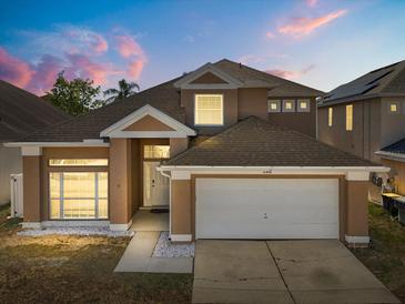 Charming two-story home featuring a well-manicured lawn and attached two-car garage at 386 Riggs Cir, Davenport, FL 33897