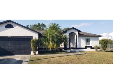 Charming single-story home with well-maintained landscaping, dark shutters and a two-car garage at 614 Gaul Way, Kissimmee, FL 34759