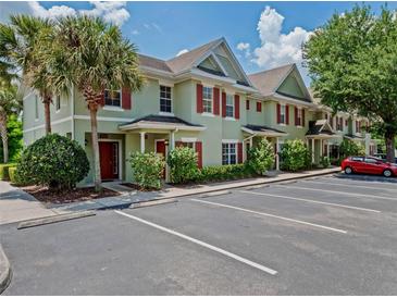 Inviting townhouse exterior with a palm tree and ample parking at 10154 Regent Square Dr # 201, Orlando, FL 32825