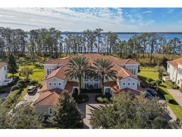 Stunning aerial view of the home with a red tile roof, surrounded by lush greenery and beautiful scenery at 10339 Kensington Shore Dr # J-202, Orlando, FL 32827