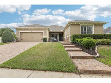 Charming single-story home featuring a well-manicured lawn, brick driveway, and welcoming curb appeal at 11725 Verrazano Dr, Orlando, FL 32836