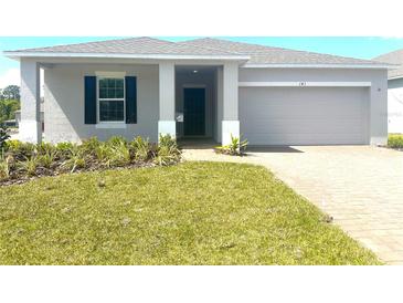 Charming single-story home featuring a well-manicured lawn, neutral paint and attached two car garage at 141 Addle Hill Ct, Deland, FL 32720