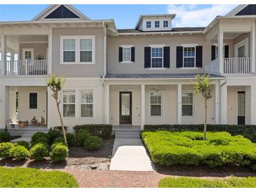 Inviting townhome with a well manicured lawn, covered entry, and stylish architectural details at 1516 Resolute St, Celebration, FL 34747