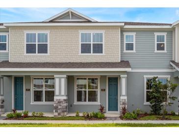 Charming townhome featuring a teal door, stone accents, and light neutral siding at 16284 Hamlin View St, Winter Garden, FL 34787