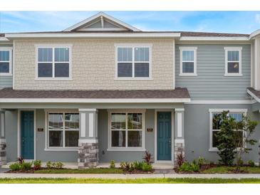Charming townhouse featuring a covered entrance, complemented by verdant landscaping and a quaint front lawn at 16290 Hamlin View St, Winter Garden, FL 34787