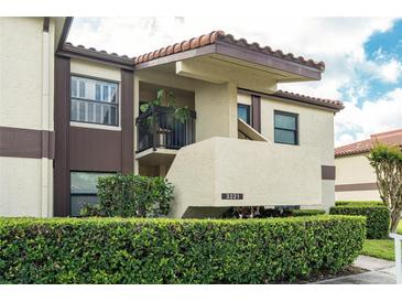 Inviting two-story condo featuring stucco exterior, decorative roof, and well-maintained front garden at 3221 Westridge Blvd # 103, Orlando, FL 32822