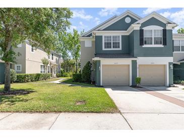 Charming two-story townhome with attached garages, lush lawn, and well-maintained landscaping in a quiet community at 5037 Hawkstone Dr, Sanford, FL 32771