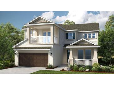 Charming two-story home featuring a covered front porch, balcony, and a two-car garage nestled among mature trees at 5223 Quillback Ln, St Cloud, FL 34771