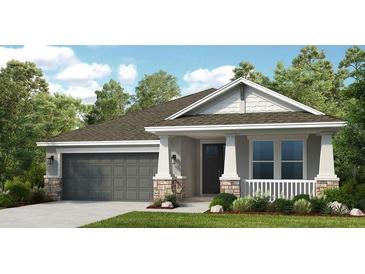 Charming single-Gathering home featuring stone accents, a two-car garage, and a covered front porch at 5259 Quillback Ln, St Cloud, FL 34771