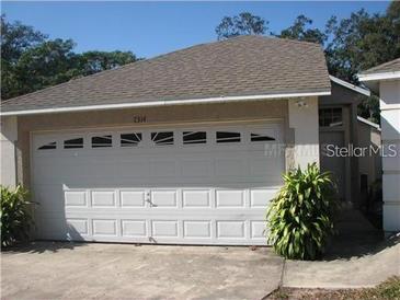 Attached one-car garage with modern door and adjacent front entry at 7314 Seena Ct, Orlando, FL 32835