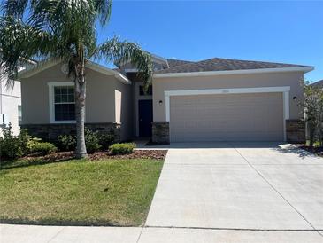 Charming single-Gathering home featuring a well-manicured lawn and a two-car garage at 1711 Penrith Loop, Orlando, FL 32824