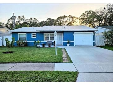 Charming blue single-story home with lush front lawn and a long driveway leading to a one car garage at 1720 Hope Dr, Ormond Beach, FL 32174