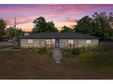 Charming single-story home featuring lush landscaping and a welcoming blue front door under a colorful sunset at 197 Flame Ave, Maitland, FL 32751