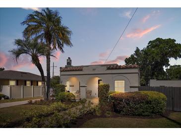 Charming bungalow featuring lush landscaping, arched entryway and a classic Mediterranean-style roof at 2107 Delaney Ave, Orlando, FL 32806