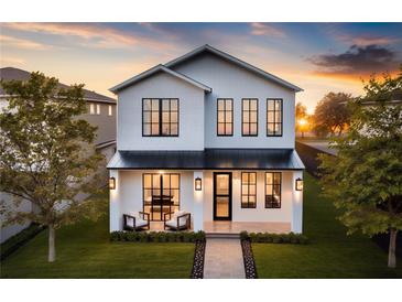 Striking two-story home featuring a modern design, sleek black windows, and inviting front porch at 22 W Hazel St, Orlando, FL 32804