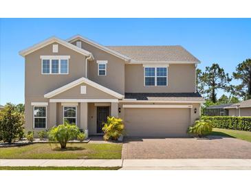 Charming two-story home with a brick driveway and well-maintained landscaping showcasing curb appeal at 340 Irving Bend Dr, Groveland, FL 34736