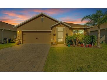 Charming single-story home with brick driveway, well-maintained lawn, and mature palm tree at 424 Lazio Cir, Debary, FL 32713