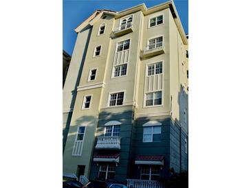 Multi-story condo building with balconies, multiple windows and neutral colored stucco facade at 8761 The Esplanade # 6, Orlando, FL 32836
