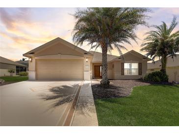 Charming single-story home with a well-manicured lawn and mature palm trees at 12711 Se 97Th Terrace Rd, Summerfield, FL 34491
