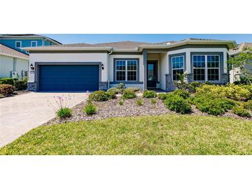 Charming single-story home featuring a well-manicured lawn, beautiful landscaping, and a two-car garage at 13828 Tybee Beach Ln, Orlando, FL 32827