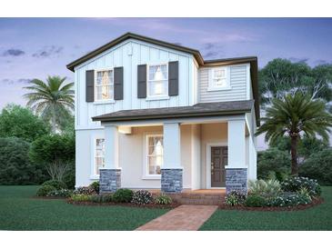 Charming two-story home with a welcoming front porch and stone accents, complemented by a beautifully landscaped yard at 17353 Beachgrass Aly, Winter Garden, FL 34787