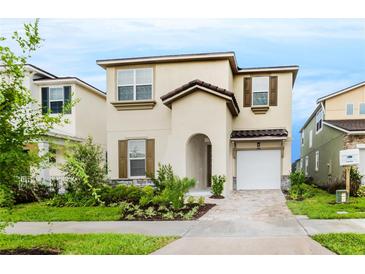 Charming two-story home with a well-manicured lawn, neutral color scheme and an attached one car garage at 1781 Sawyer Palm Pl, Kissimmee, FL 34747