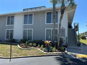 Inviting condo exterior with gray siding, well-manicured landscaping, and a charming staircase leading to the upper units at 1935 Conway Rd # T6, Orlando, FL 32812