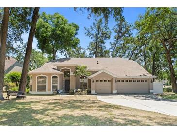 Charming single-story home featuring a three-car garage, mature trees, and inviting curb appeal at 2082 Nexus Ct, Apopka, FL 32712