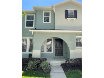 Charming two-story home with an arched entrance and well-maintained landscaping at 2164 Black Mangrove Dr, Orlando, FL 32828