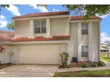 Two-story home featuring an attached garage and a red tile roof at 2565 Albion Ave # 2, Orlando, FL 32833