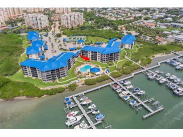 Gorgeous aerial view of waterfront condos, a community pool, tennis courts, and private boat slips at 2700 N Peninsula Ave # 215, New Smyrna Beach, FL 32169