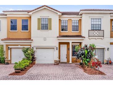 Charming townhome with a brick driveway, attached garage and colorful landscaping at 3462 Allegra Cir, St Cloud, FL 34772