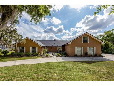 Charming brick home features well-manicured lawn, driveway, and inviting landscaping at 789 Errol Pkwy, Apopka, FL 32712