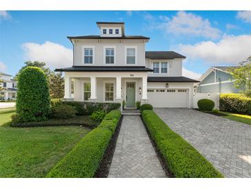 Charming two-story home featuring a manicured lawn, brick walkway, and a welcoming front porch with classic white pillars at 1114 Georgia Blvd, Orlando, FL 32803
