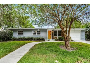 Charming single-story home featuring a well-manicured lawn, inviting walkway, and bright orange front door at 117 Exeter Ave, Longwood, FL 32750